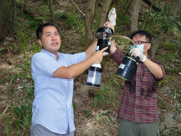 In response to a report of a Japanese encephalitis (JE) case in Tuen Mun last week, Food and Environmental Hygiene Department (FEHD) staff today (August 12) continued to conduct JE vector surveillance and anti-mosquito measures in the district. Photo shows FEHD staff demonstrating the operation of a mosquito trap at So Kwun Wat Road in Tuen Mun