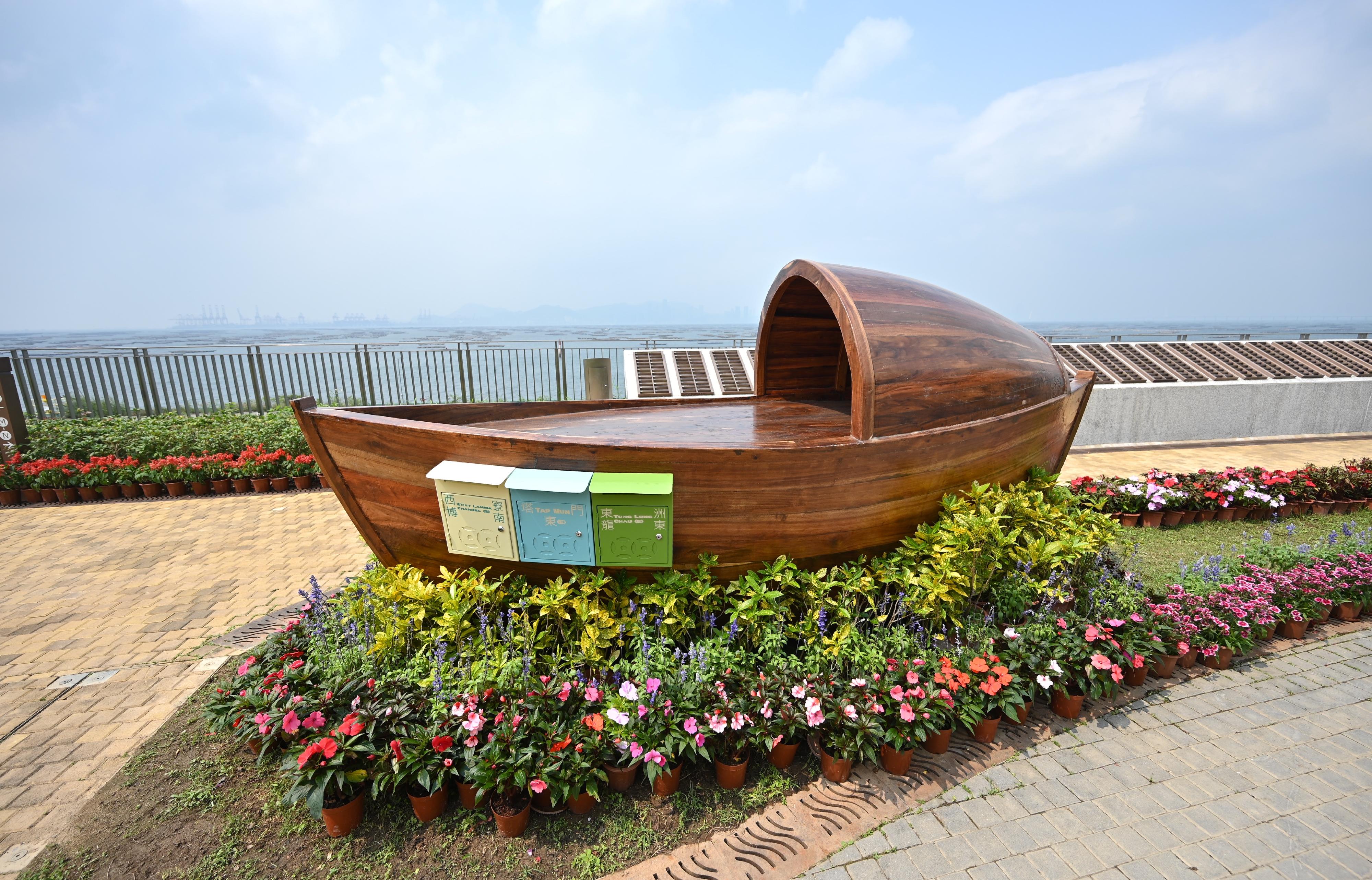 The Food and Environmental Hygiene Department said today (April 3) that to further enhance its green burial services, a wooden artwork has been installed at the Garden of Remembrance (GoR) in Tsang Tsui, Tuen Mun. Memorial post boxes with local characteristics on the artwork allow families of those who have used green burial services (including scattering of cremains at sea and in GoRs) to send their blessings and remembrance to the deceased by posting memorial notes