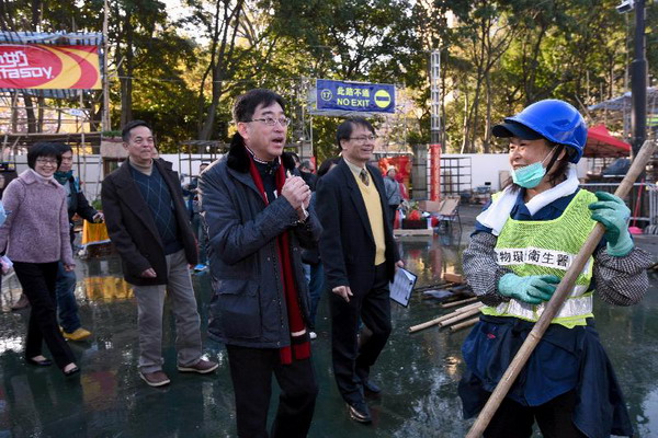 食物環境衞生署(食環署)人員今日(二月八日)清早在年宵市場結束後開始清理場地。圖示食物及衞生局局長高永文(右三)及食環署署長劉利群(左一)在維多利亞公園巡視清理工作及為員工打氣。